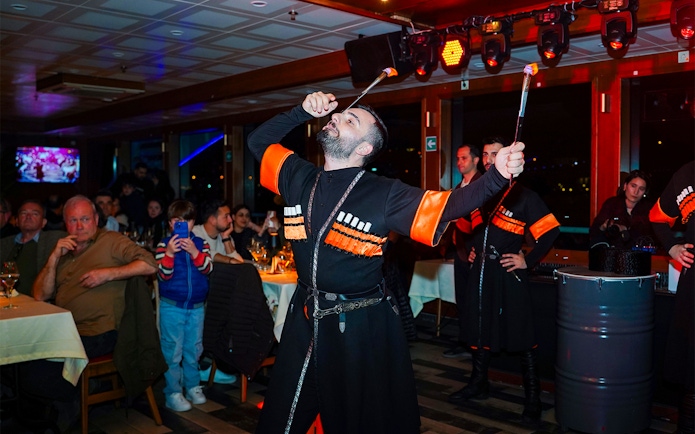 Performer with fire act on Bosphorus dinner cruise with live audience.