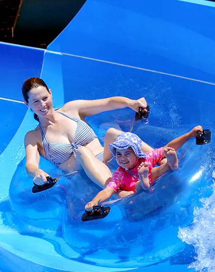 Mother and child enjoying a water slide at Wet 'n' Wild, Gold Coast.