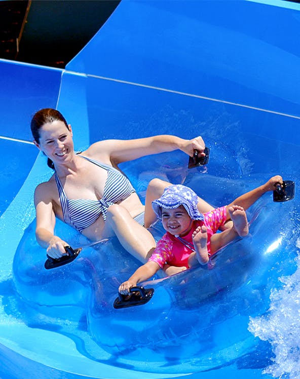 Mother and child enjoying a water slide at Wet 'n' Wild, Gold Coast.