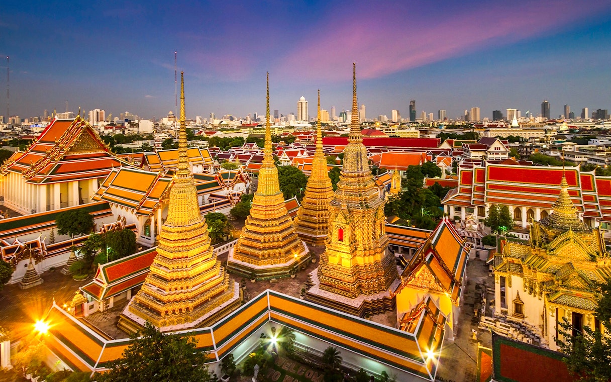 Wat Pho and Wat Arun temples at sunset in Bangkok, Thailand.