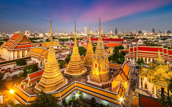 Wat Pho and Wat Arun temples at sunset in Bangkok, Thailand.