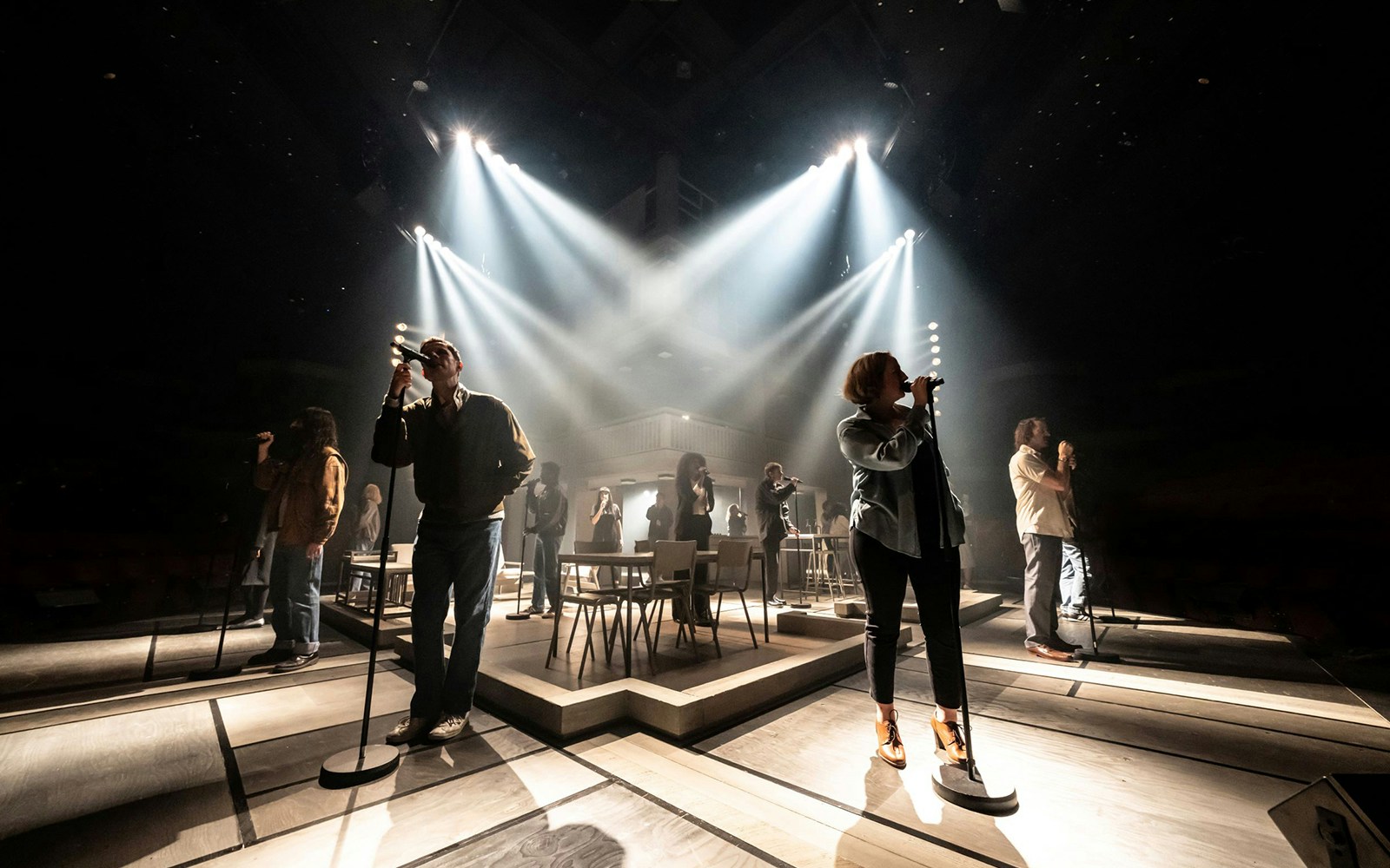 Performers on stage during "Standing At The Sky's Edge" musical, under dramatic lighting.