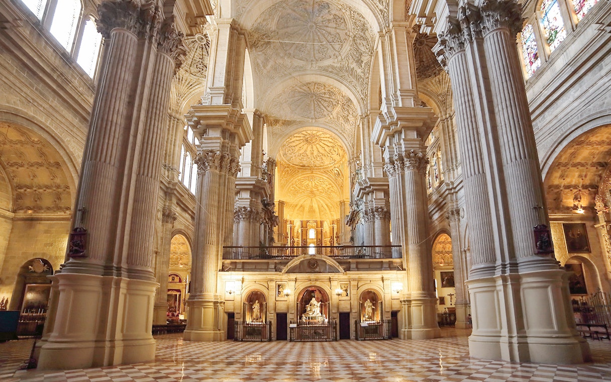 Interior of the Cathedral of Málaga with ornate columns and vaulted ceilings.