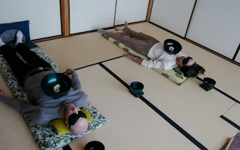 Participants experiencing a Japanese sound bath with singing bowls in Kyoto.
