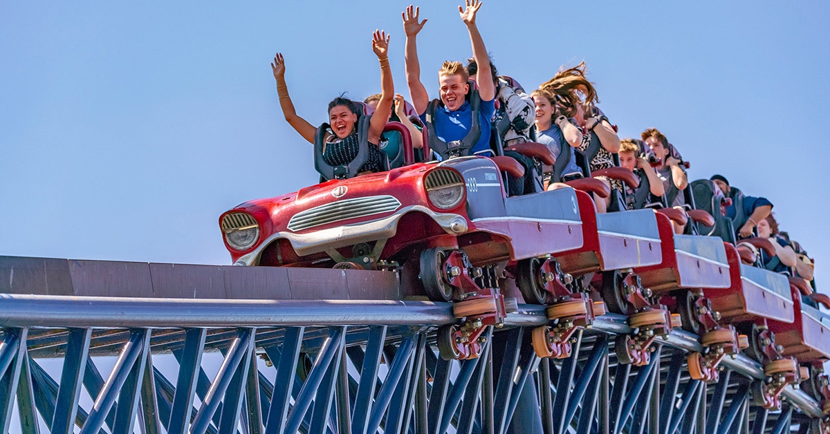 Riders with raised arms on THE SWARM roller coaster at Thorpe Park Resort.
