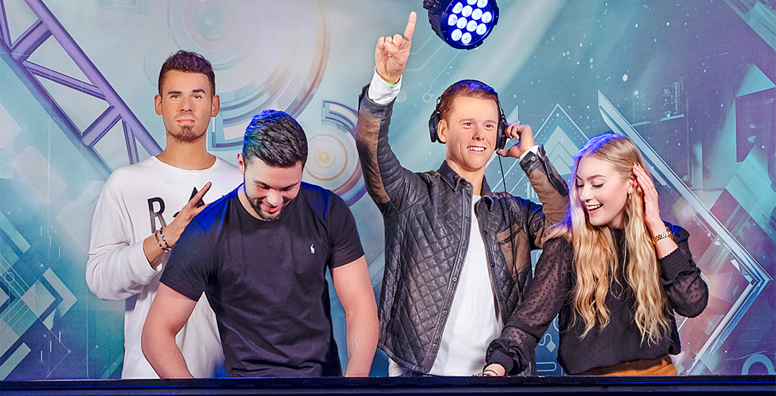 DJ figures at Madame Tussauds Amsterdam with visitors enjoying music.