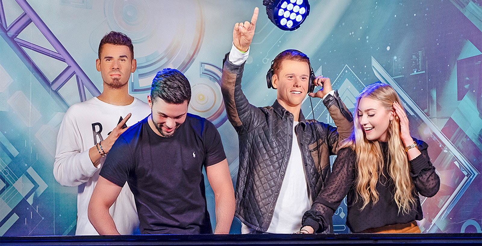 DJ figures at Madame Tussauds Amsterdam with visitors enjoying music.