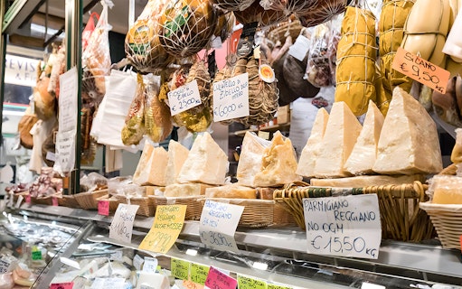 Cheese and cured meats displayed at a local market in Florence during a Tuscan cooking class tour.