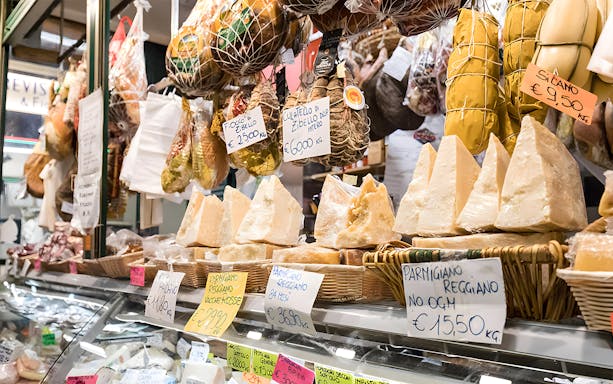 Cheese and cured meats displayed at a local market in Florence during a Tuscan cooking class tour.