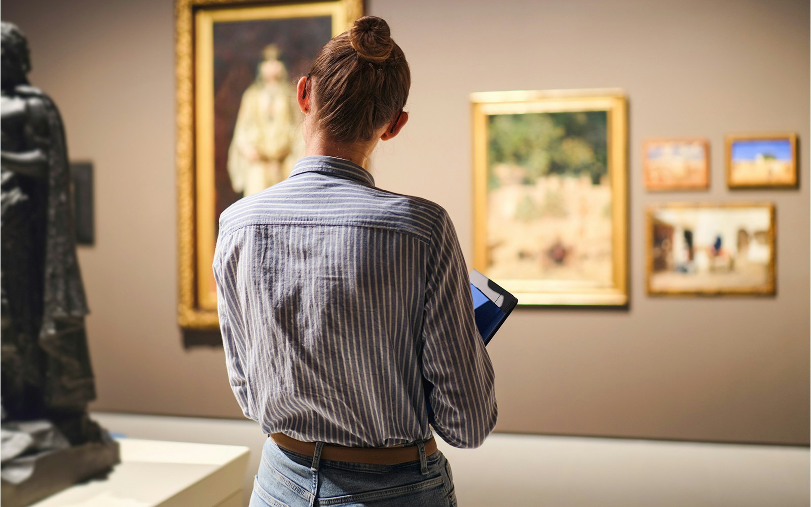 Female visitor in historical museum looking at art object