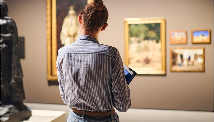 Female visitor in historical museum looking at art object