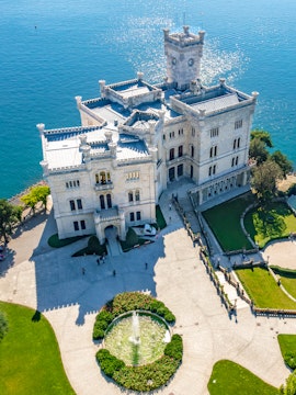 Miramare Castle overlooking the Gulf of Trieste, Italy, with surrounding gardens.
