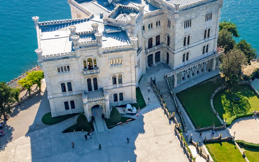 Miramare Castle overlooking the Gulf of Trieste, Italy, with surrounding gardens.