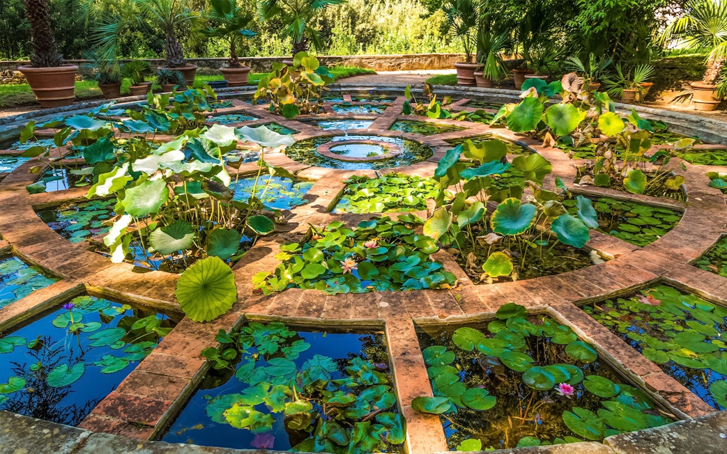 Upper Botanical Garden at Boboli Gardens with manicured hedges and statues in Florence, Italy.