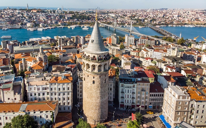 Galata Tower overlooking Istanbul cityscape and Bosphorus Bridge.