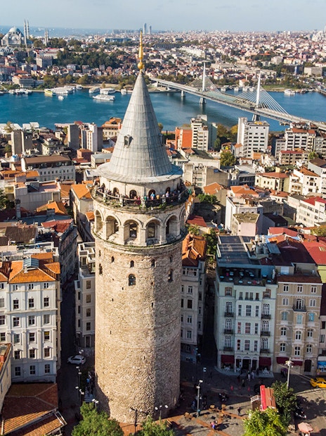 Galata Tower overlooking Istanbul cityscape and Bosphorus Bridge.