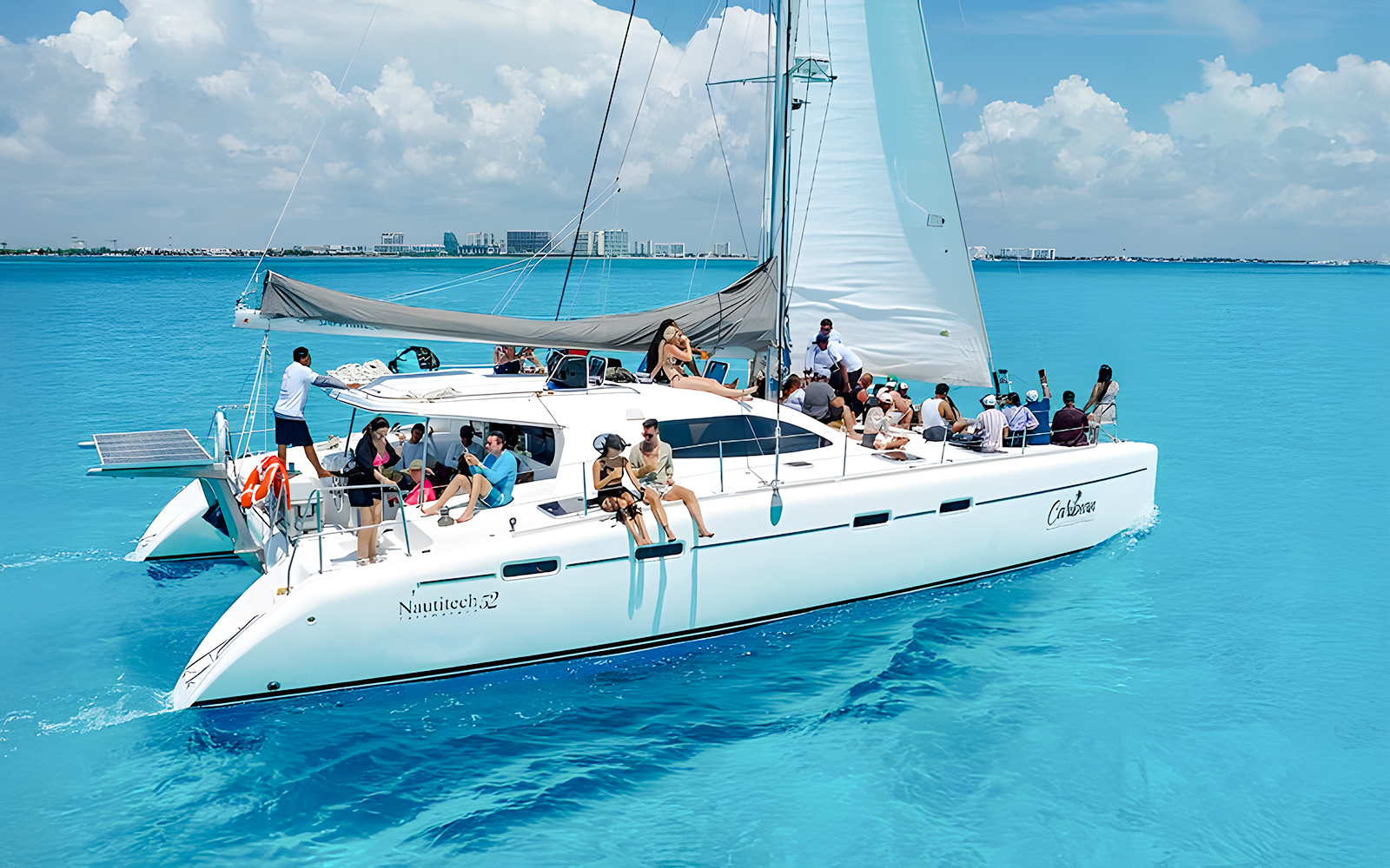Catamaran cruise with passengers on turquoise Caribbean Sea near Cancún, Mexico.