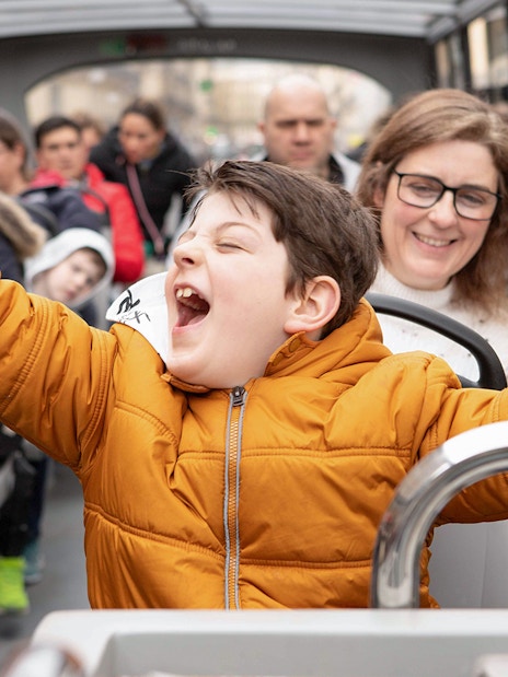 Joyful child celebrating quiz win on Tootbus tour in Paris.