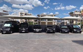 Tour vans parked under canopies for Sounion Half-Day Tour in Greece.