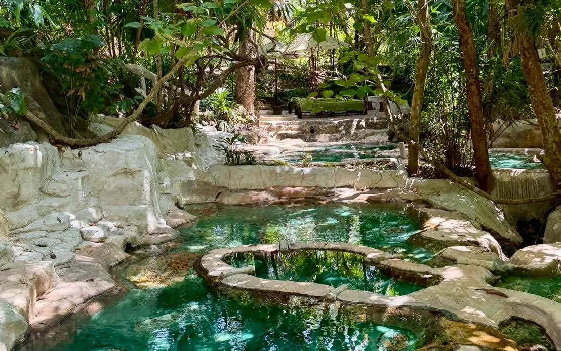 Natural hot spring pools surrounded by lush greenery in Krabi, Thailand.