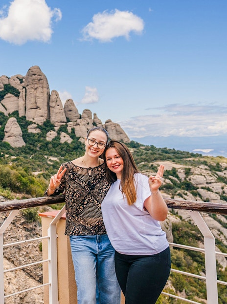 Tourists posing for a photo with Montserrat mountains in the background during hike to monastery.