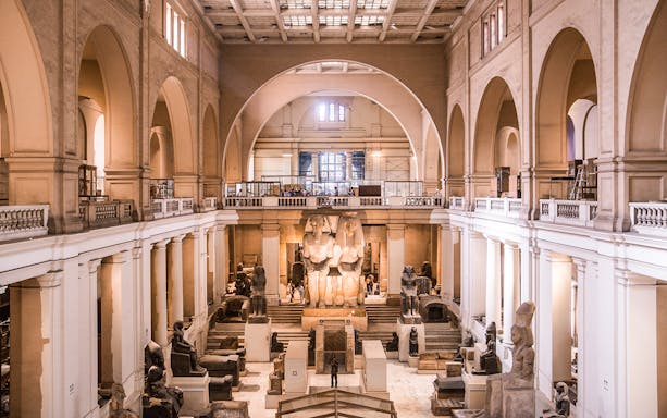 Interior of the Egyptian Museum in Cairo with ancient statues and artifacts.