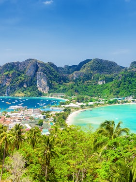 Phuket to Phi Phi Island view with lush greenery, turquoise waters, and boats in the bay.