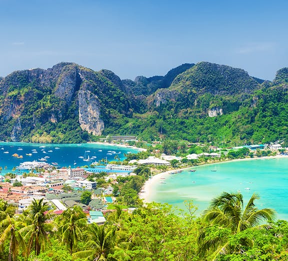 Phuket to Phi Phi Island view with lush greenery, turquoise waters, and boats in the bay.
