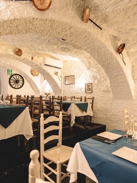 Dining area at Venta el Gallo with set tables and rustic decor, Granada Flamenco Show.