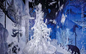 Swarovski Crystal Worlds installation with icy tree and winter-themed mural in Innsbruck.