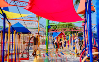 Children navigating colorful rope bridges at Ko Fun Kids Rope Park, Phuket.