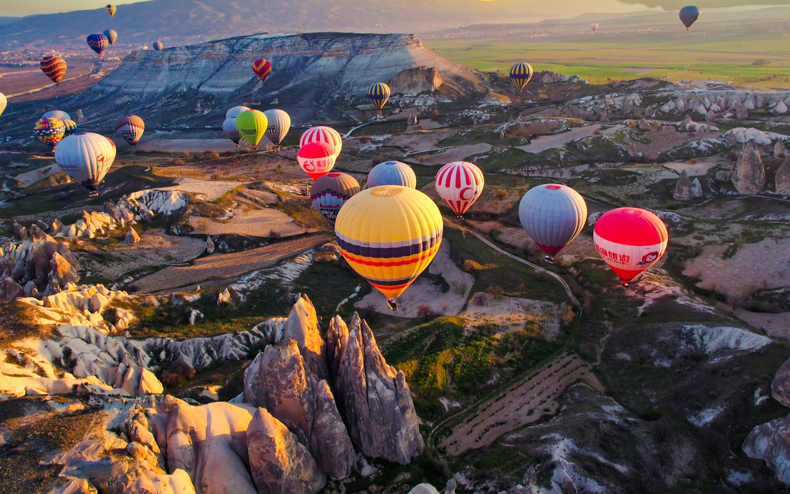 Hot air balloons over Cappadocia's unique rock formations at sunrise.