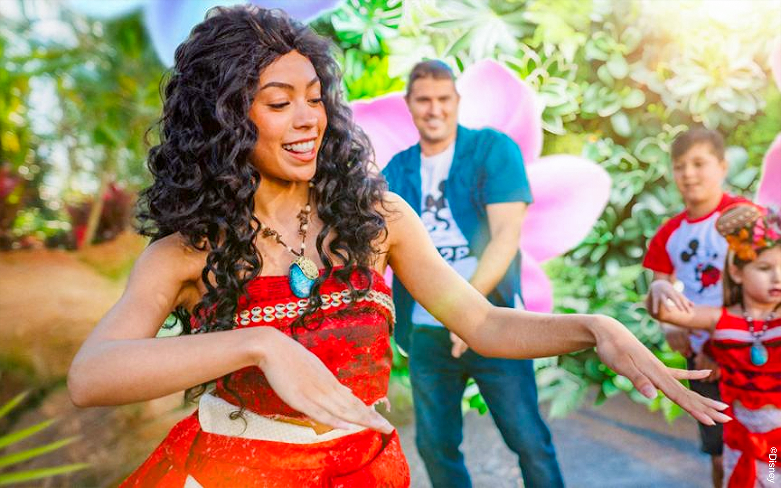 Moana cosplayer performing at Disneyland Paris with children watching.
