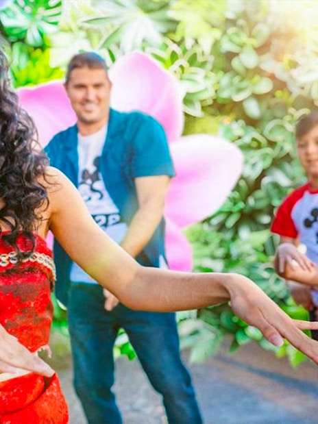 Moana cosplayer performing at Disneyland Paris with children watching.