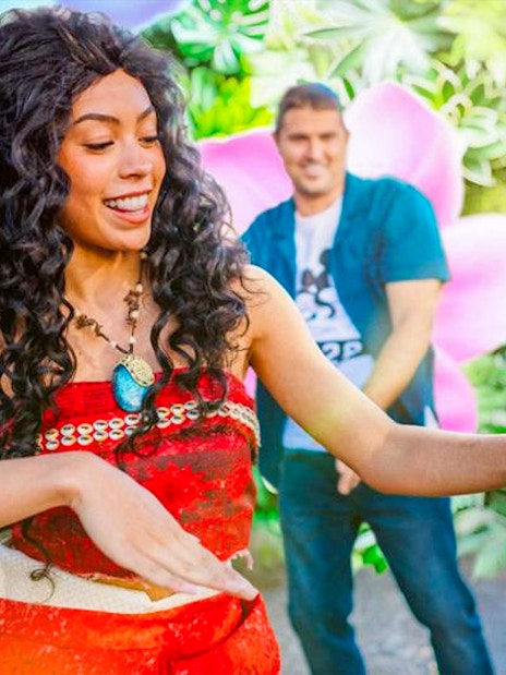 Moana cosplayer performing at Disneyland Paris with children watching.