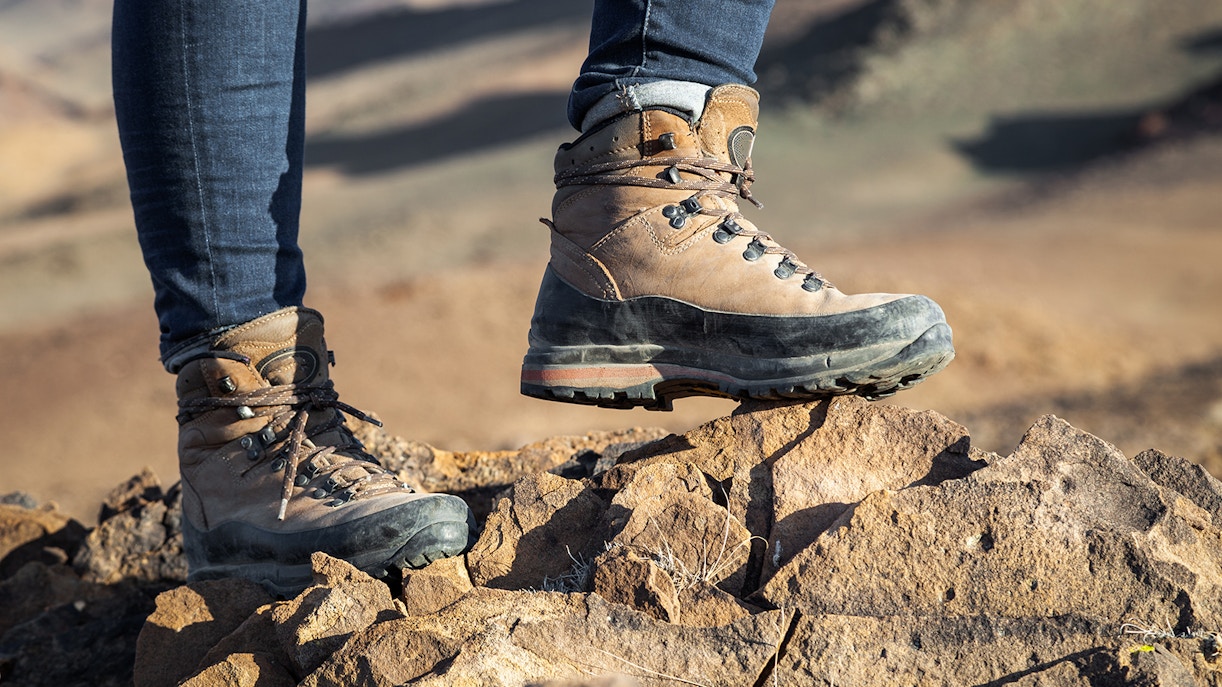 Hiking boots on rocky terrain in a desert landscape.