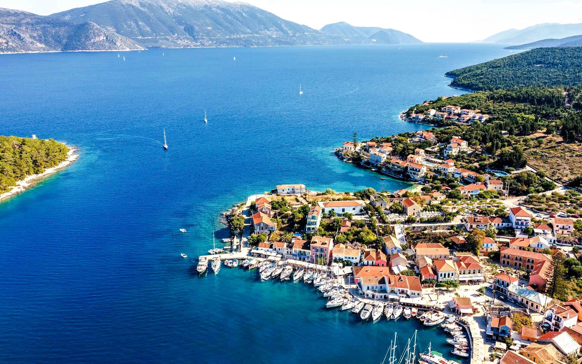 Aerial view of Fiskardo village with boats in the harbor, Kefalonia island, Greece.