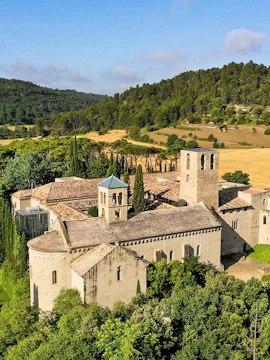 Món Sant Benet monastery surrounded by lush greenery and rolling hills.