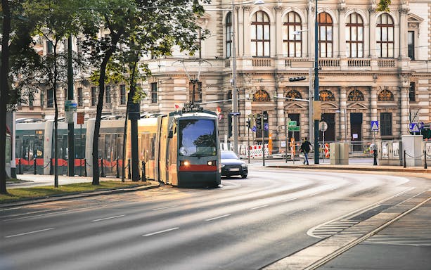 Tram passing by historic building in Vienna city center.