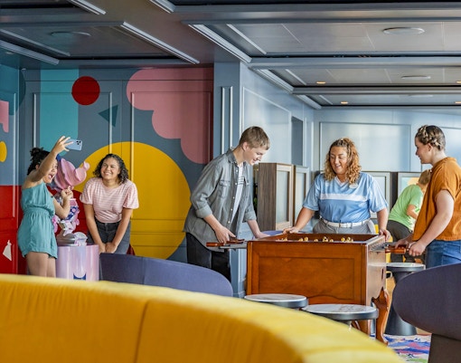 Teens enjoying activities at Vibe club on Disney Cruise ship.