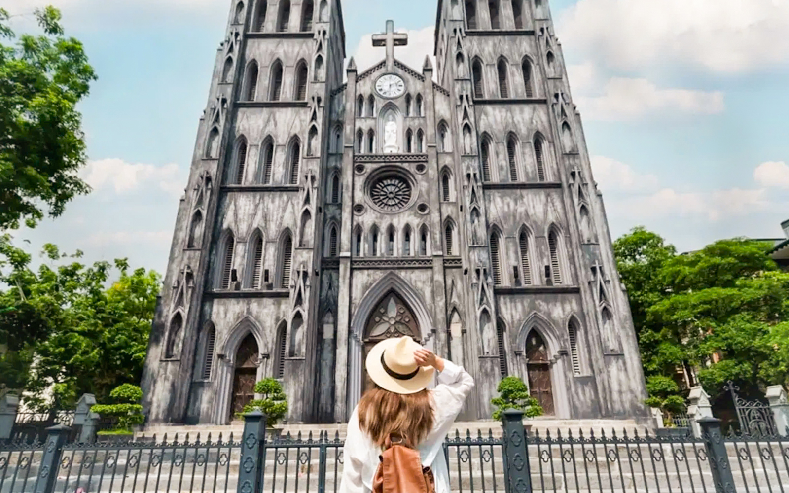 Woman admiring St. Joseph's Cathedral in Hanoi on a guided half-day city tour.