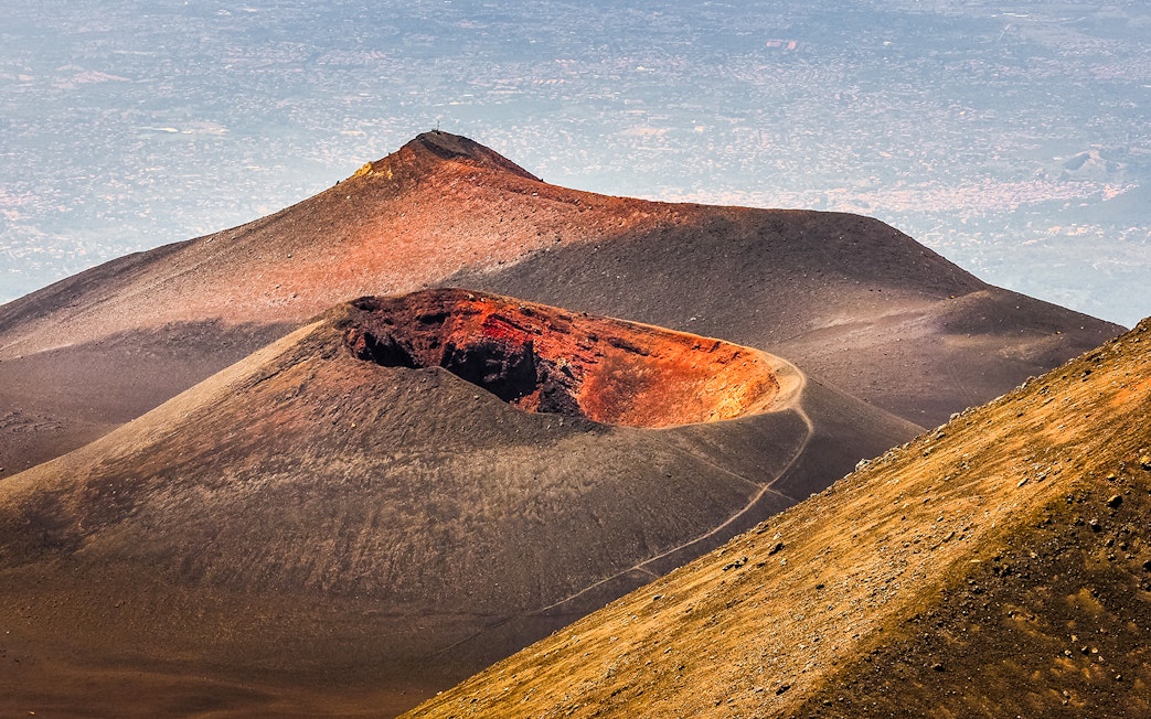Mount Etna crater with surrounding landscape on a guided afternoon tour.