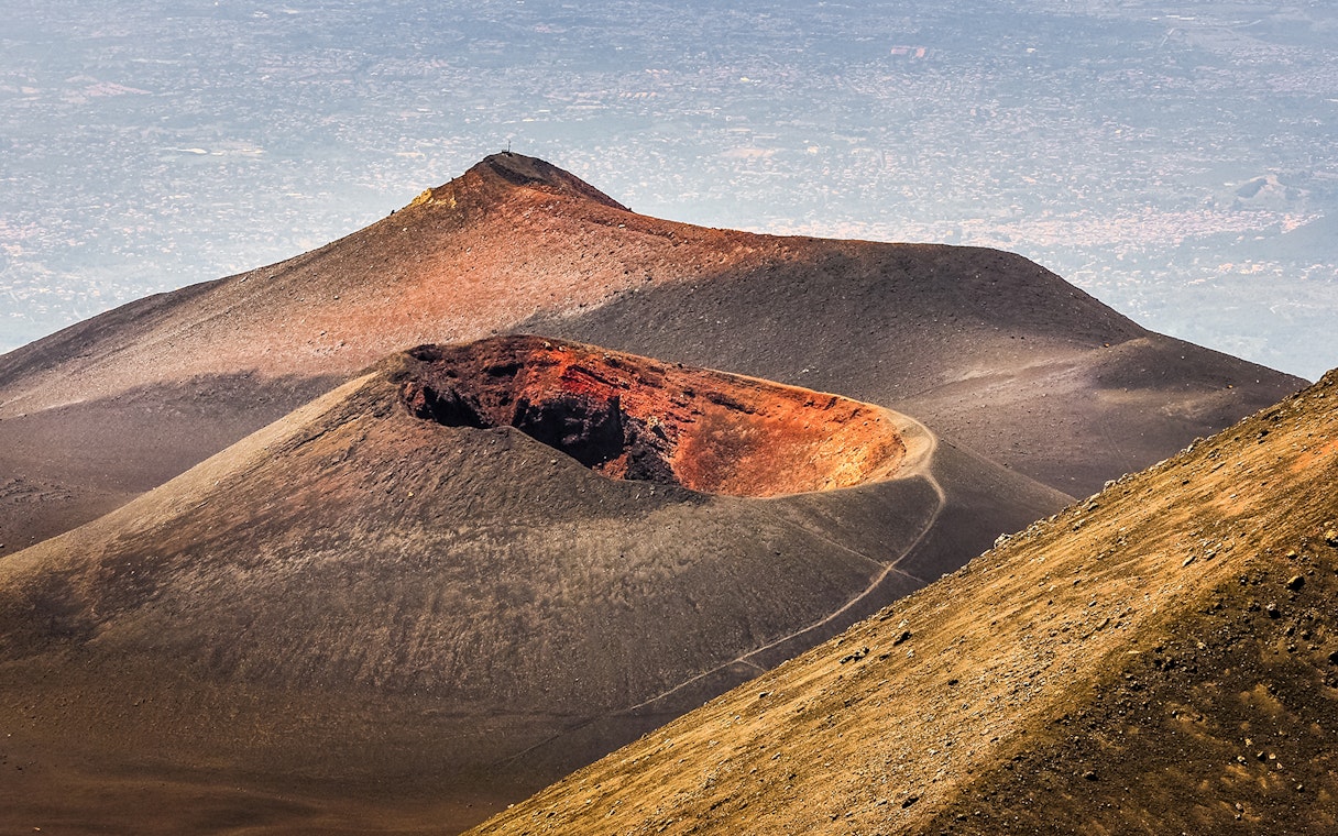 Mount Etna crater with surrounding landscape on a guided afternoon tour.