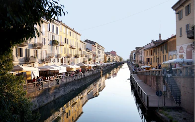 Canal view with cafes and historic buildings in Milan's Navigli district.