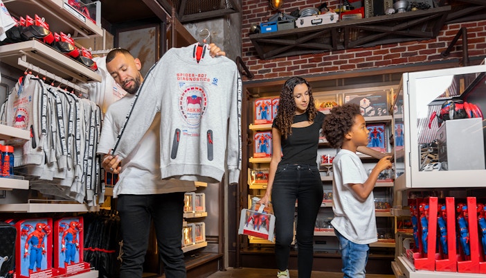 Shoppers browsing Spider-Man merchandise at Mission Equipment shop, Disneyland Paris.