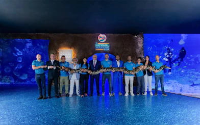 Group holding a large snake at the National Aquarium Abu Dhabi.