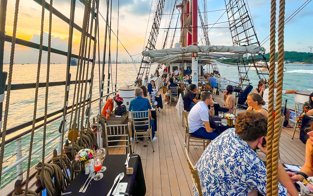 Sunset dinner cruise on The Royal Albatross with guests dining on deck.