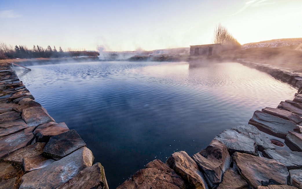 Secret Lagoon hot spring surrounded by stone walls in Gamla Laugin, Iceland.