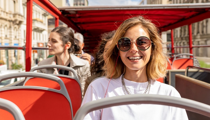 Woman listening to audioguide on the hop on hop off bus.