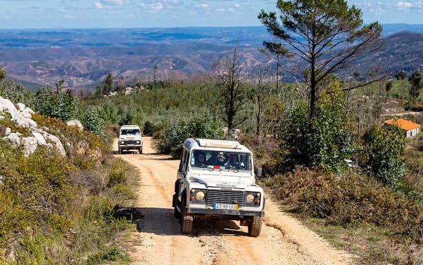 Jeep driving on a dirt road through Algarve countryside during full-day tour.